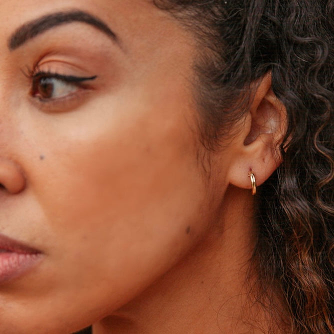Elegant small featherweight gold hoops, perfect for a minimalist jewelry style