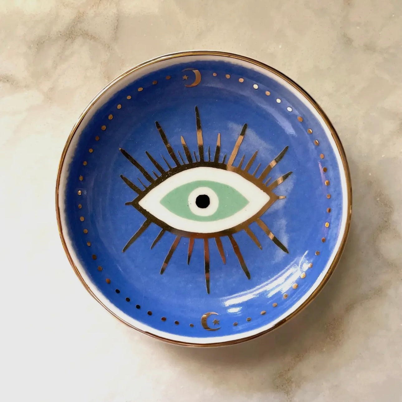 Eye of Protection white ceramic trinket dish with colorful hand-painted designs and gold edge.